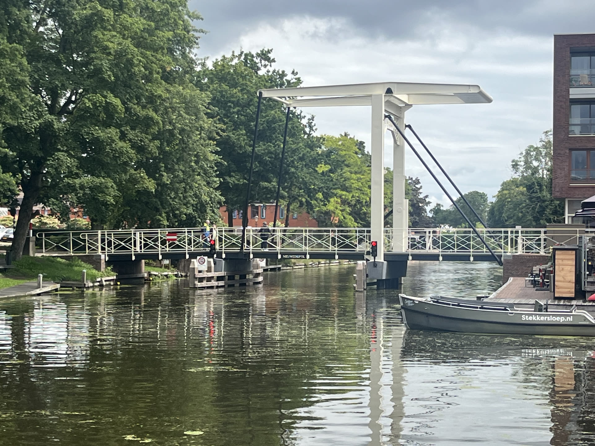 De Nieuwedieptil, een witte ophaalbrug over het water in Appingedam